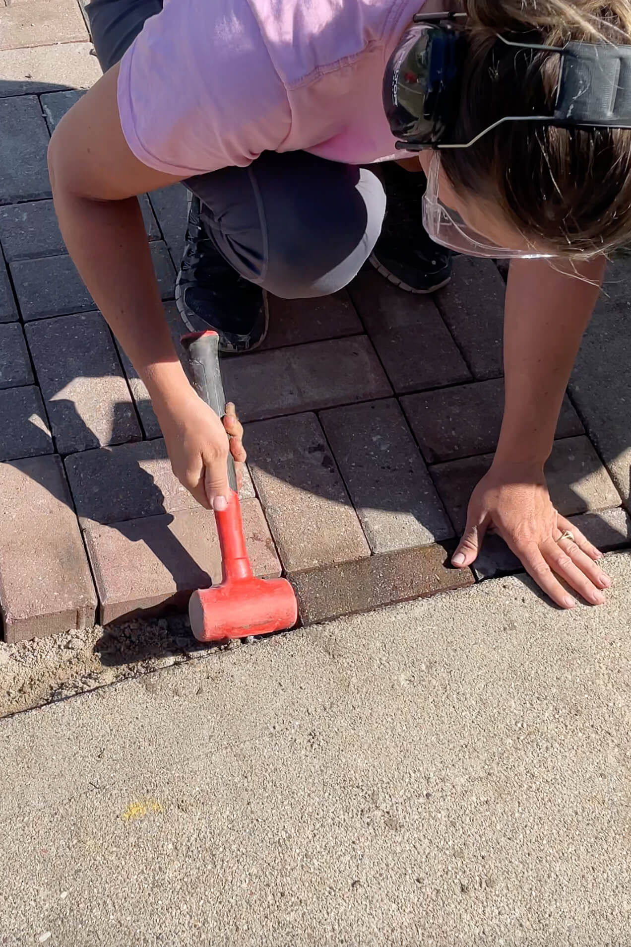 Using a rubber mallet while installing pavers.